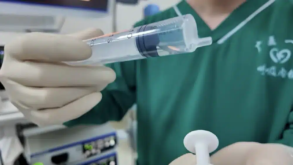 Chinese physician preparing stem cell therapy administration — MSC infusion procedure at Grade 3A hospital
